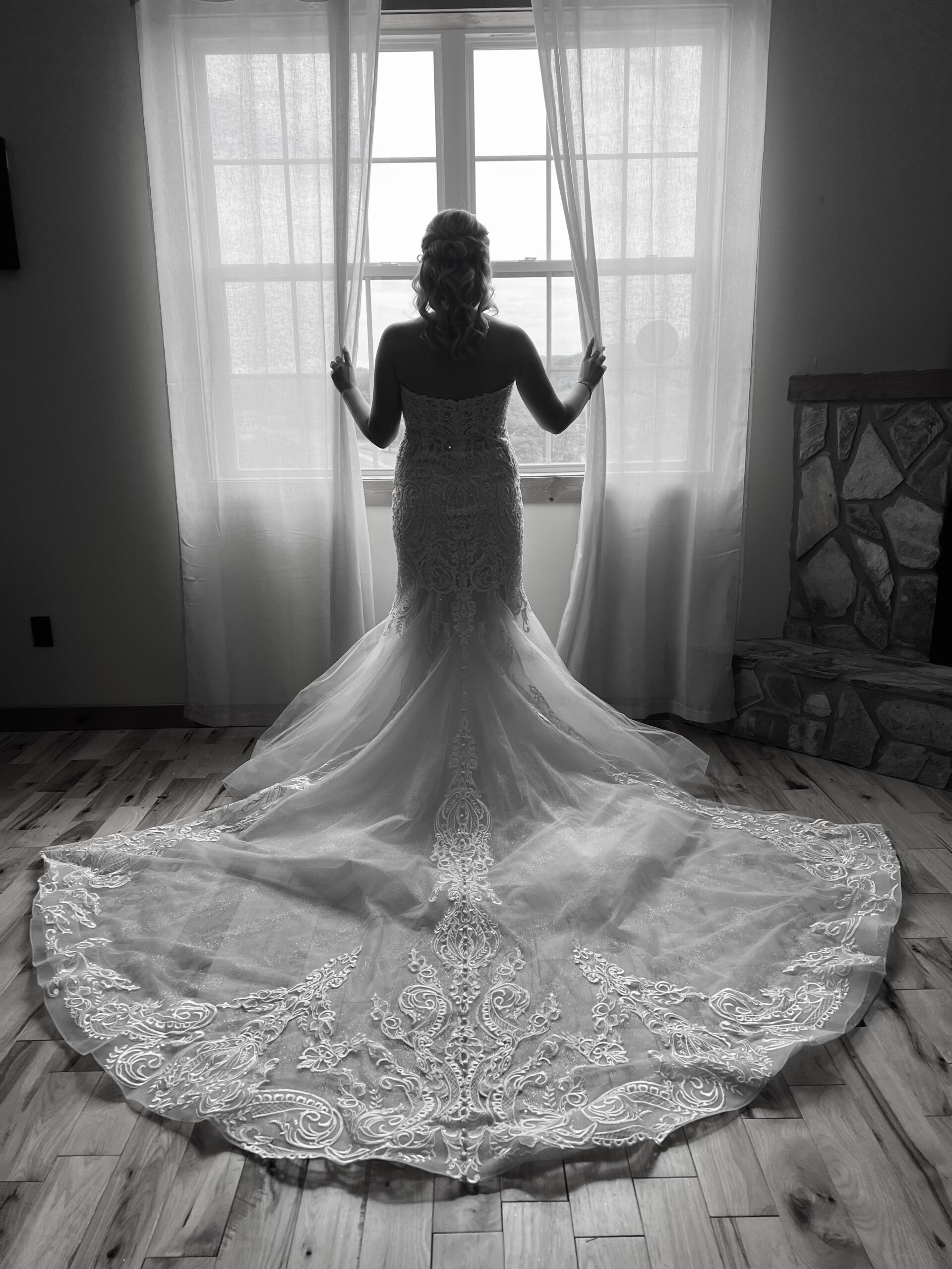 back profile of bride standing before a window