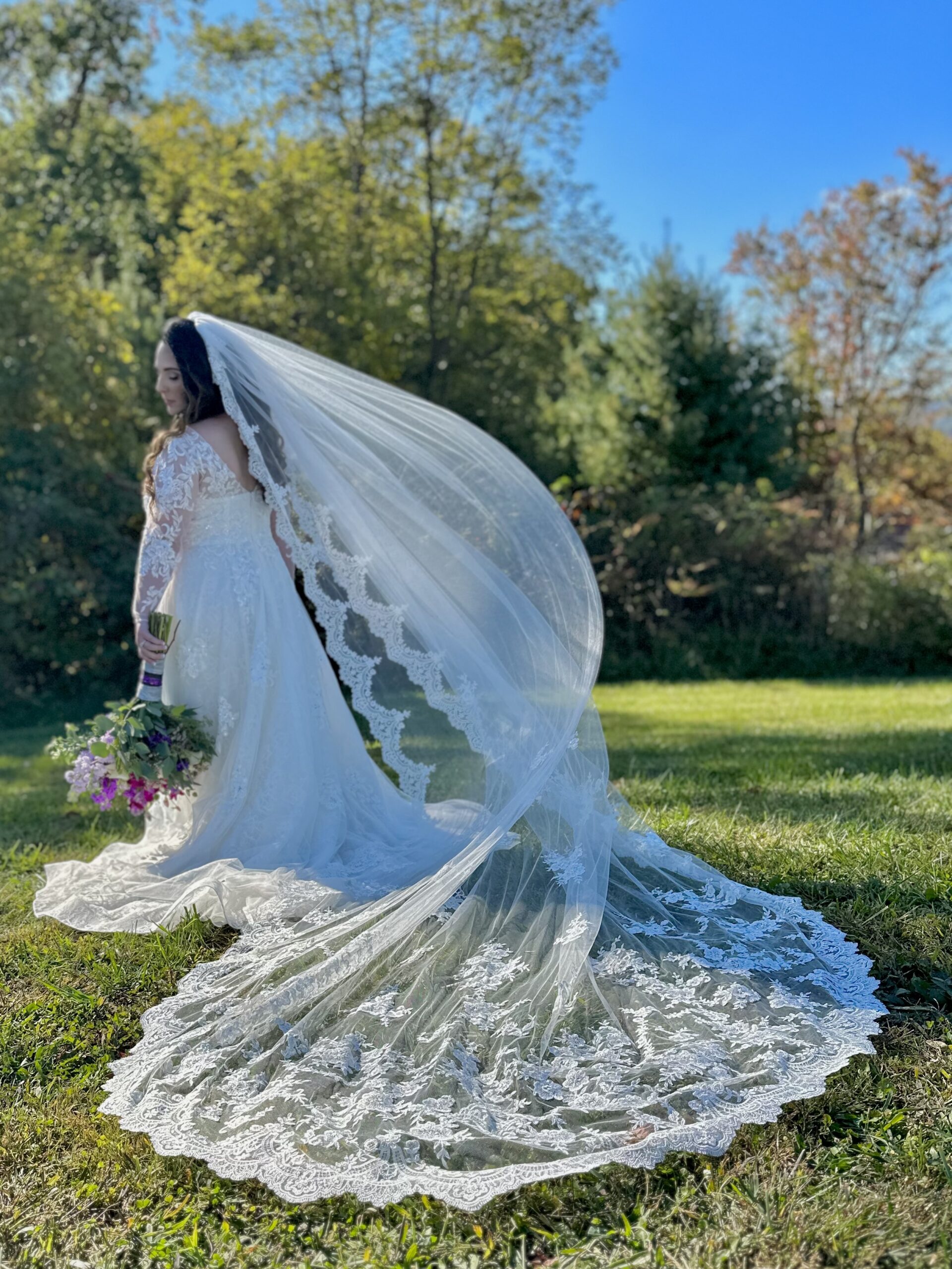 lovely bride in a vintage lace wedding dress with a long veil