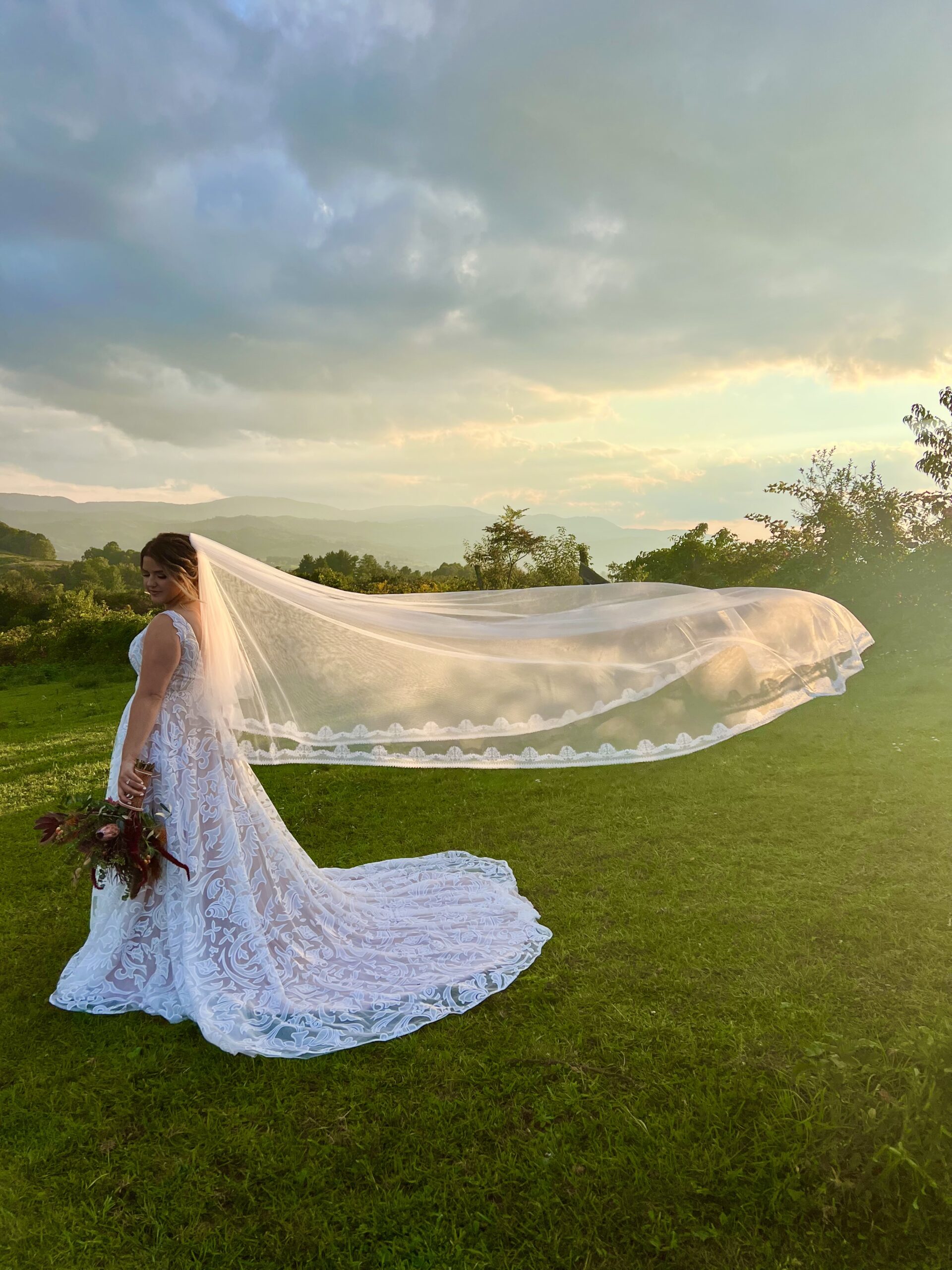 bride posing outdoor with veil flowing